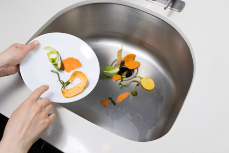 woman throwing food junks on the drain